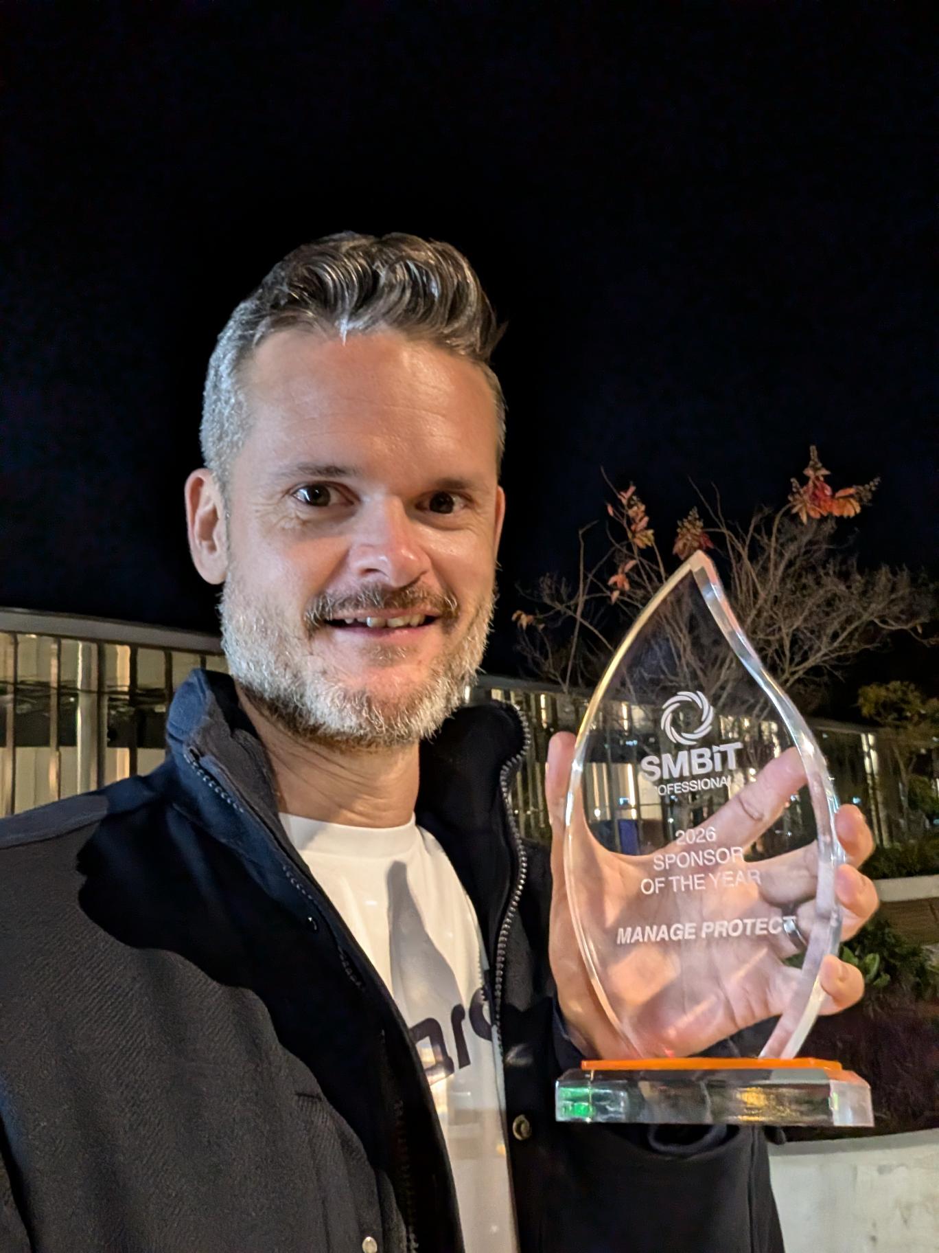 Zac holding the 2026 SMBIT Sponsor of the Year award